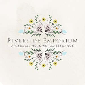 May include: A logo for Riverside Emporium featuring the text "RIVERSIDE EMPORIUM" and "ARTFUL LIVING, CRAFTED ELEGANCE" centered between two symmetrical floral illustrations with yellow, light blue, and purple petals on green stems.