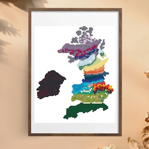 May include: A framed print featuring a colorful, pixelated map of a landmass, likely an island. The map is segmented into various regions, each represented by a unique color palette, including shades of green, blue, orange, and purple. The frame is a dark brown.