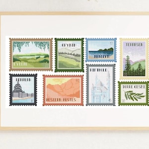 Puede incluir: Una obra de arte enmarcada con nueve diseños de punto de cruz que se asemejan a sellos postales. Cada sello muestra un paisaje diferente, incluyendo montañas y agua. Los sellos son de varios colores e incluyen texto como "ADARLAN" y "WESTERN RASTES".