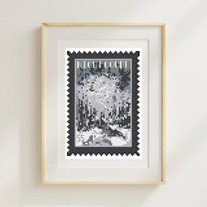 May include: Framed artwork featuring a cross-stitch design resembling a postage stamp. The stamp is black with a detailed landscape scene in shades of gray and blue. The text "NIGHT COURT" is at the top, and the number "55" is at the bottom. The frame is light wood.