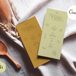 K&ouml;nnte beinhalten: Zwei Thanksgiving-Men&uuml;karten mit goldfarbenem und gr&uuml;nem Hintergrund. Die Karten zeigen den Text "THANKSGIVING" in einer modernen Schriftart und eine Liste von Gerichten, darunter Truthahn, Kartoffelp&uuml;ree, Preiselbeer-Sauce und K&uuml;rbiskuchen.