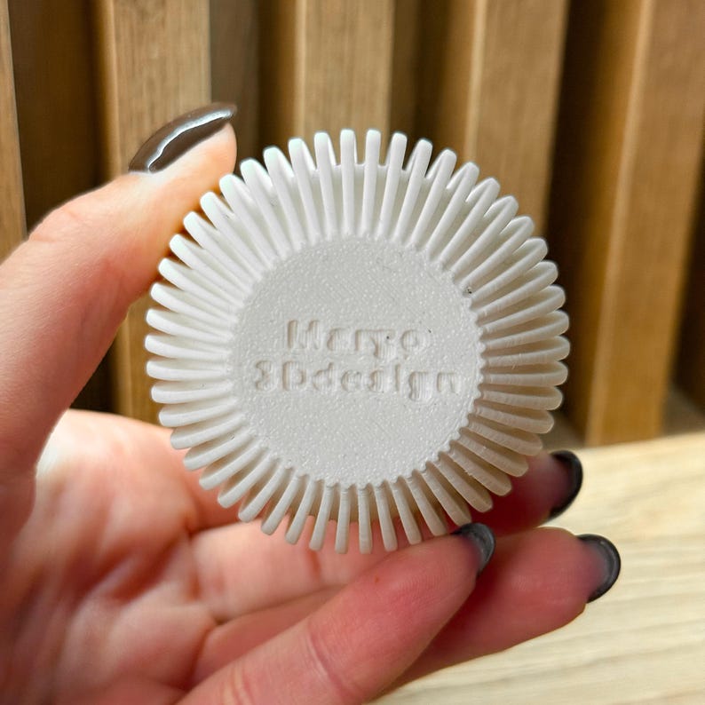 May include: White round object with a textured surface and the words "Mero 3Ddesign" printed on the front.