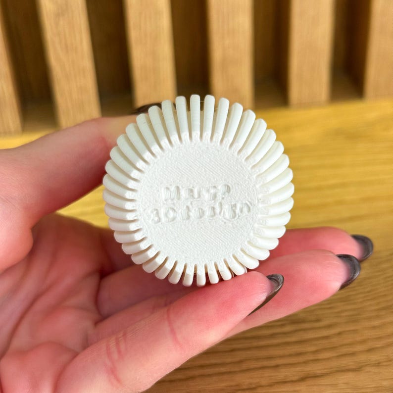 May include: White round bottle stopper with a decorative design and the text "Merry & Bright" embossed on the top.