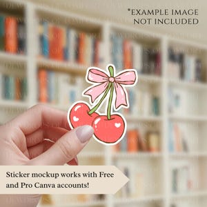 May include: A sticker featuring two red cherries with white heart details, connected by a green stem and a pink bow. The sticker is held in a hand. Text on the image reads: Sticker mockup works with Free and Pro Canva accounts!
