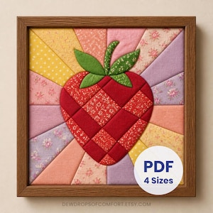 May include: A framed fabric wall art piece featuring a central red strawberry made of quilted squares, surrounded by a sunburst pattern of triangular fabric segments in yellow, pink, and lavender floral prints. A white circular label reads PDF 4 Sizes.