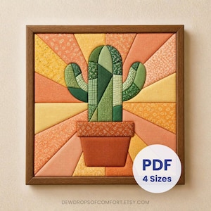 May include: A square framed wall art piece featuring a fabric-pieced cactus in shades of green, set against a sunburst background of orange, yellow, and peach patterned fabric. A brown pot holds the cactus. Text reads PDF 4 Sizes.