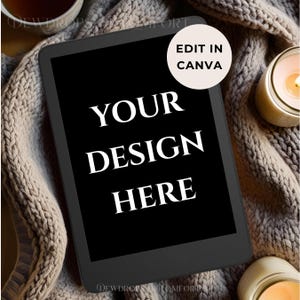 May include: A black tablet with the text "YOUR DESIGN HERE" in white. A circular sticker with the text "EDIT IN CANVA" is in the upper right corner. The tablet rests on a beige knitted blanket, with candles and a cup of tea in the background.