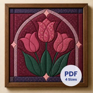 May include: A square wall hanging featuring a quilted fabric design of three pink tulips with green stems and leaves, framed in wood. The background is deep burgundy with a light pink arched border. Text reads PDF 4 Sizes.