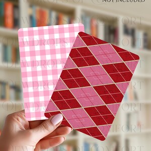 May include: Two decorative cards with different patterns. One card features a pink and white gingham pattern, while the other showcases a red and pink argyle design. The cards are held in front of a blurred background of a bookshelf.