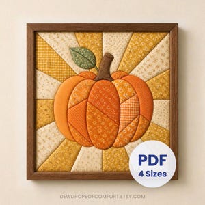 May include: A square framed fabric wall art piece featuring a central pumpkin made of various orange patterned fabric segments with a brown stem and green leaf. The background consists of radiating yellow and cream fabric strips. Text reads PDF 4 Sizes.