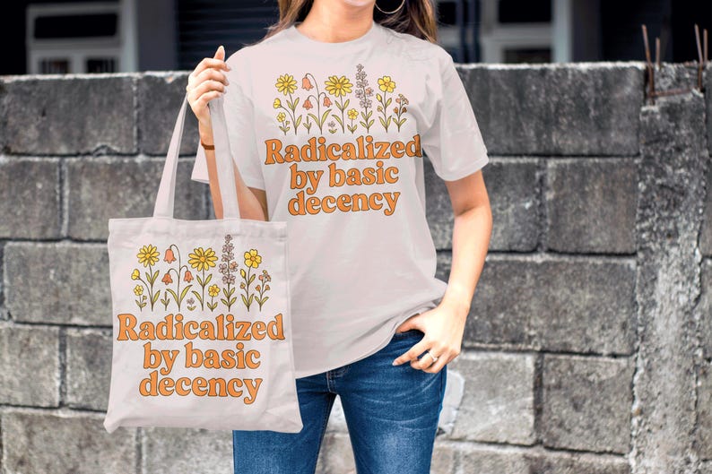 May include: White t-shirt and tote bag with a floral design and the text "Radicalized by basic decency" in orange. The tote bag is held by a person wearing blue jeans.