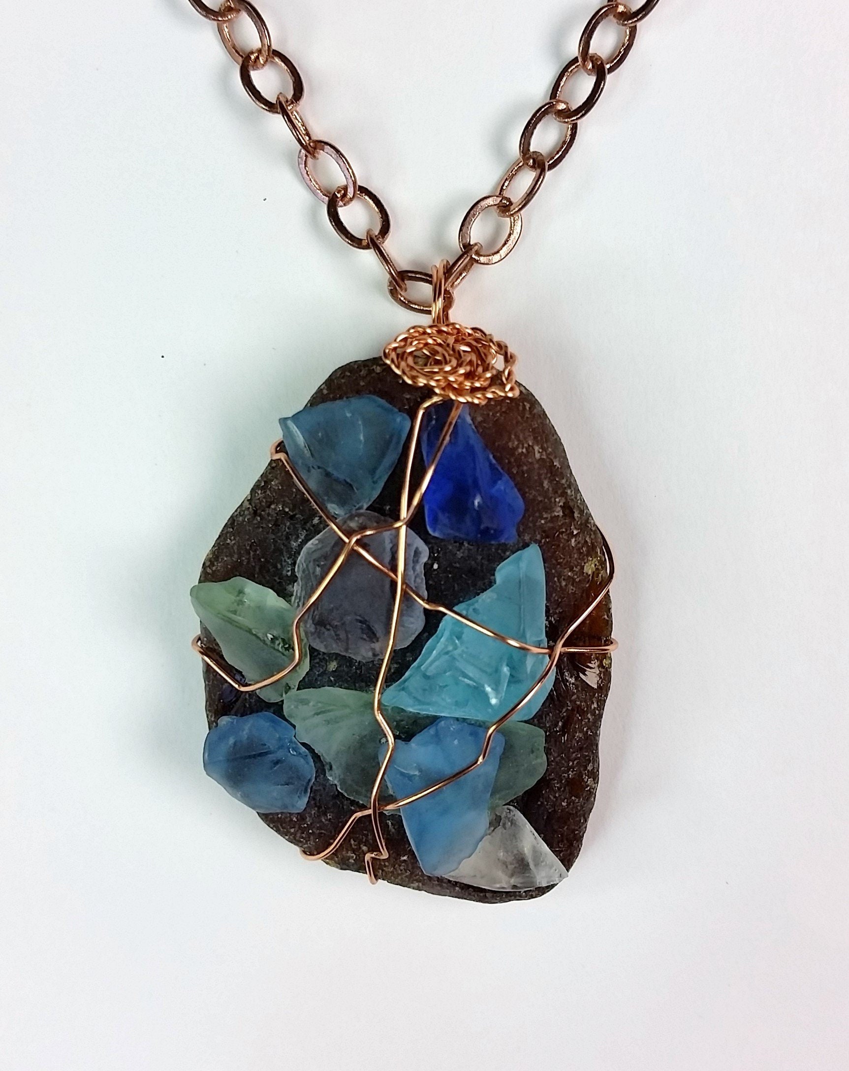 Unique triangular pendant with a pale sea glass wrapped in silver coated copper wire and a smokey glass bead dangling under.
