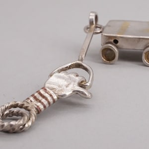 Unusual Modernist Sterling & 14k Hand pulling wagon moving wheels charm