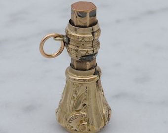 May include: A gold-toned metal seal with an ornate design and a loop for attaching to a chain. The seal has a removable top that is also gold-toned.