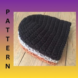 May include: A stack of three crocheted beanies in black, gray, and orange. The word "PATTERN" is vertically displayed in black letters on the left side of the image. The beanies are stacked on a wooden surface.