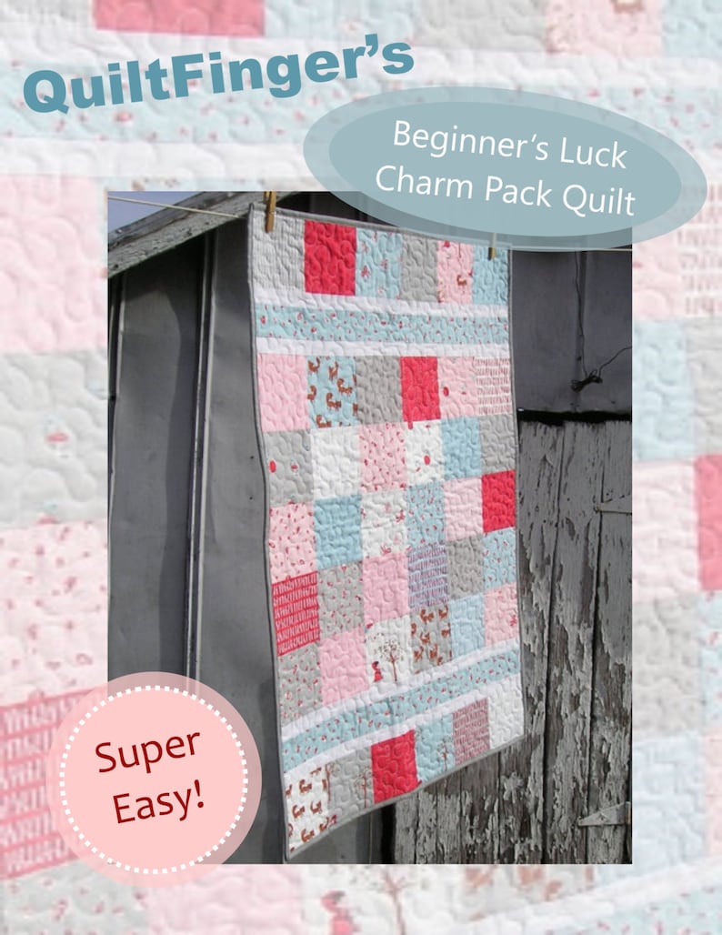 May include: A pink, blue, and gray quilt with a "Beginner's Luck Charm Pack Quilt" title and "Super Easy!" text. The quilt is hanging on a gray wooden surface.