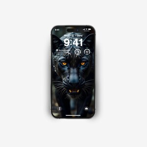 Puede incluir: Un pantera negra con ojos amarillos brillantes mira fijamente a la c&aacute;mara. La pantalla del tel&eacute;fono muestra la hora 9:41 y la fecha mi&eacute;rcoles 7 de julio a las 7:29 PM. El tel&eacute;fono tambi&eacute;n muestra un icono de fase lunar, una temperatura de 70 grados y un nivel de humedad del 32%.