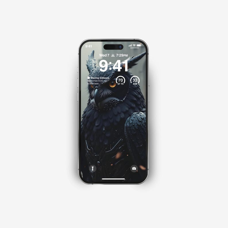 May include: A black and white phone screen displaying a dark image of an owl with yellow eyes. The time is 9:41 and the date is Wed 7. The phone screen also shows the moon phase, "Waxing Gibbous", and the battery percentage, 70%.