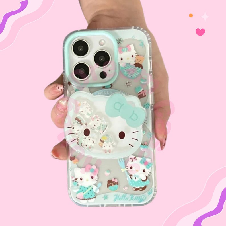 May include: Clear phone case with a Hello Kitty design and a light blue border. The case features 3D Hello Kitty characters, cupcakes, and bows. The case is held in a hand against a pink background.