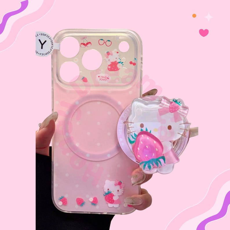 Puede incluir: Funda de tel&eacute;fono rosa con parte trasera transparente con dise&ntilde;o de Hello Kitty. La funda tiene un agarre emergente con un dise&ntilde;o de Hello Kitty y fresa. La funda tambi&eacute;n tiene un dise&ntilde;o de fresa y cereza.