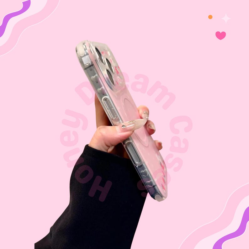 Puede incluir: Funda transparente para tel&eacute;fono con dise&ntilde;o rosa. La funda se sostiene en &aacute;ngulo, mostrando su material transparente y los detalles rosas. El fondo es rosa suave con elementos decorativos.