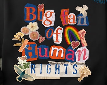 May include: Black sweatshirt with a collage design. The design includes the text "Big fan of Human Rights" in a cut-out style with red, blue, and white letters. The design also features hearts, a rainbow, and floral elements.