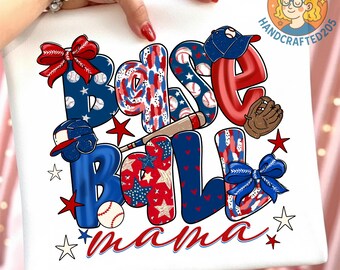 May include: White t-shirt featuring the words "BASEBALL MAMA" in a colorful design. The letters are decorated with baseballs, stars, and patriotic patterns in red, white, and blue. Includes baseball glove, bat, and bows.