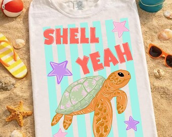 May include: White t-shirt with a colorful graphic design. The design features the words "SHELL YEAH" in coral and a cartoon turtle with a green shell and orange body. The shirt also has light blue stripes and star accents.