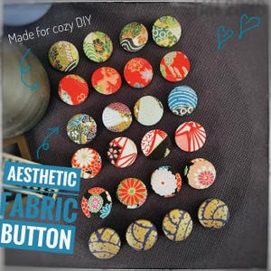 May include: A collection of aesthetic fabric buttons with various colorful patterns, including floral, geometric, and abstract designs. The buttons are round and made of fabric. Text on the image reads "Made for cozy DIY" and "Aesthetic Fabric Button".