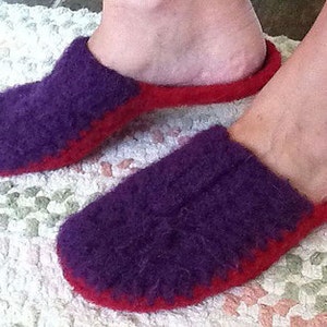 May include: Purple and red fuzzy slippers. The slippers are made of a soft, fluffy material and have a red trim around the edges.