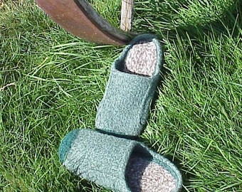 Puede incluir: Un par de zapatillas de punto verde con una plantilla de ante marrón. Las zapatillas están sobre un lecho de hierba verde.