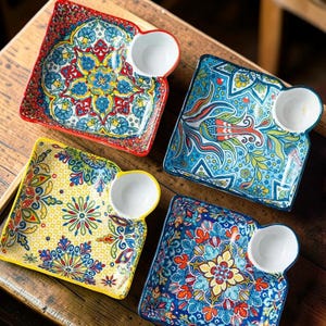 May include: A white ceramic mug with a black handle and the text "But First, Coffee" in a black, handwritten-style font. The mug is on a white surface.