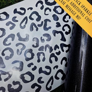 K&ouml;nnte beinhalten: Ein wei&szlig;er Klebebogen mit einem sich wiederholenden Muster aus dunklen, glitzernden Leopardenflecken. Rechts befindet sich eine Rolle aus dunklem, glitzerndem Material. Der Text auf dem Bild lautet: METALLIC BLACK SPARKLE AVAILABLE AT ADDITIONAL COST PLEASE MESSAGE ME!