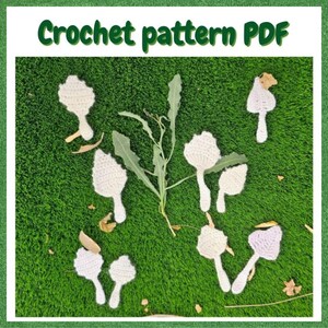 May include: A digital document titled Crochet pattern PDF featuring several off-white crocheted mushroom shapes arranged around a central green plant stem with jagged leaves. The crochet pieces are flat, textured, and varied in size.