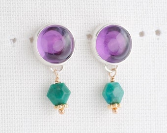 May include: A pair of silver earrings with purple amethyst stones and green gemstone accents.