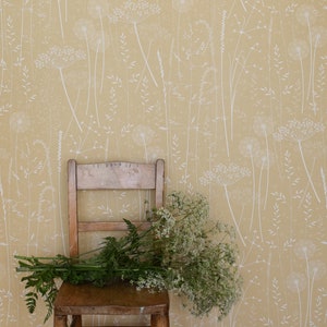 SAMPLE Paper Meadow-behang in 'oogst' van Hannah Nunn, een warme, gele botanische wandbekleding met weidezaadkoppen en grassen