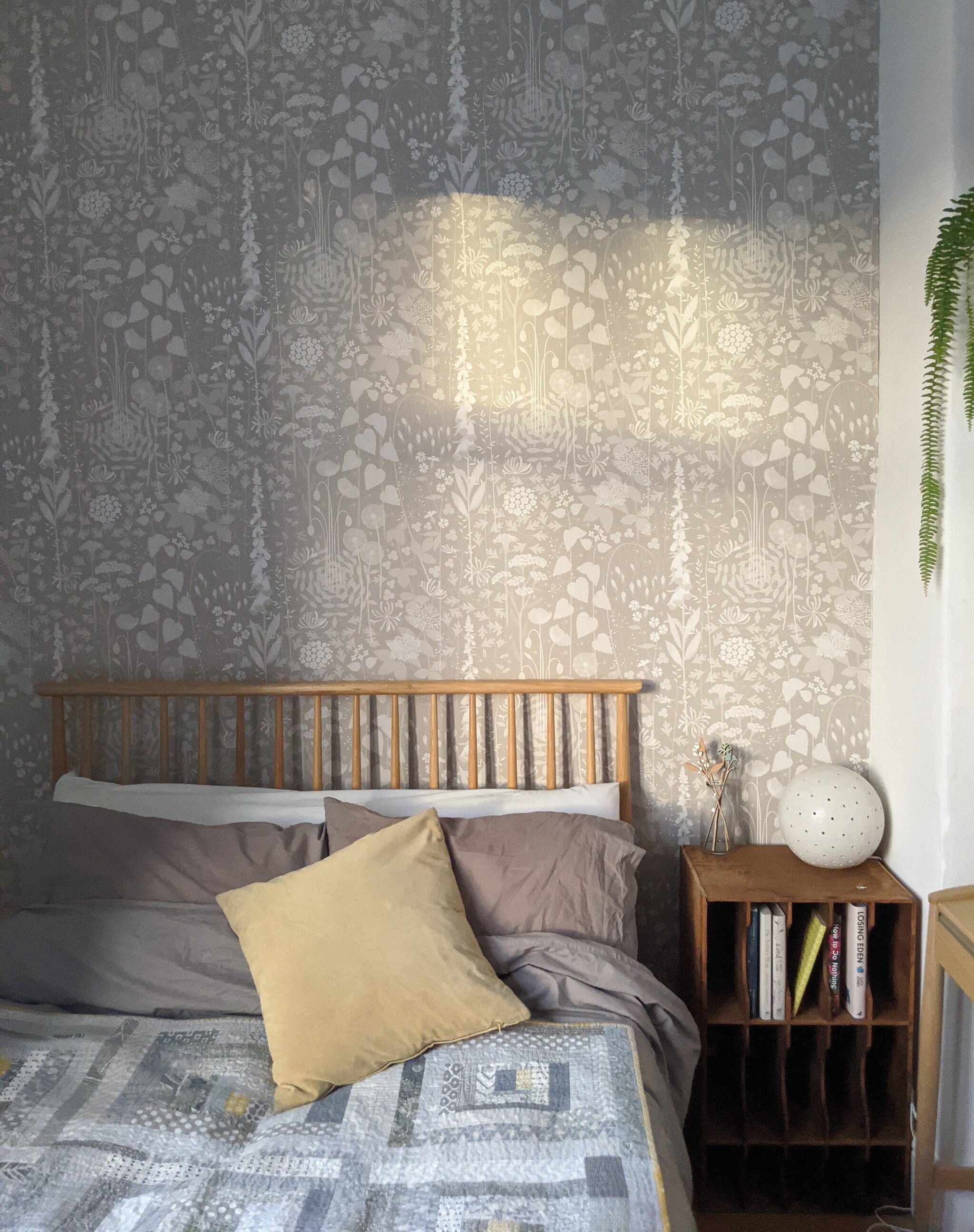 Hedgerow wallpaper in 'hush' by Hannah Nunn, a soft grey/pink botanical wall covering with a wild tangle of plants and flowers
