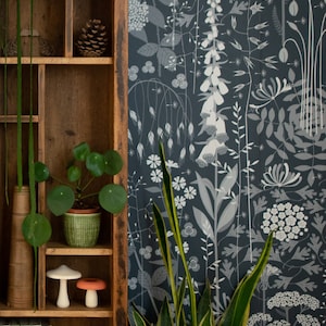 MUSTER- Heckentapete in 'nocturne' von Hannah Nunn, eine botanische Tapete mit tiefdunkelblauem Hintergrund und einem wilden Gewirr aus Pflanzen und Blumen