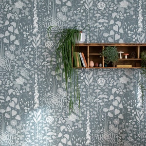 Hedgerow wallpaper in 'furling' by Hannah Nunn, a  blue/green botanical wall covering with a wild tangle of plants and flowers