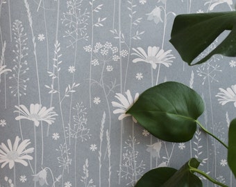 Daisy Meadow wallpaper in 'moonrise' by Hannah Nunn, a dusky blue wall covering with a summer meadow print of daisies, harebells and grasses