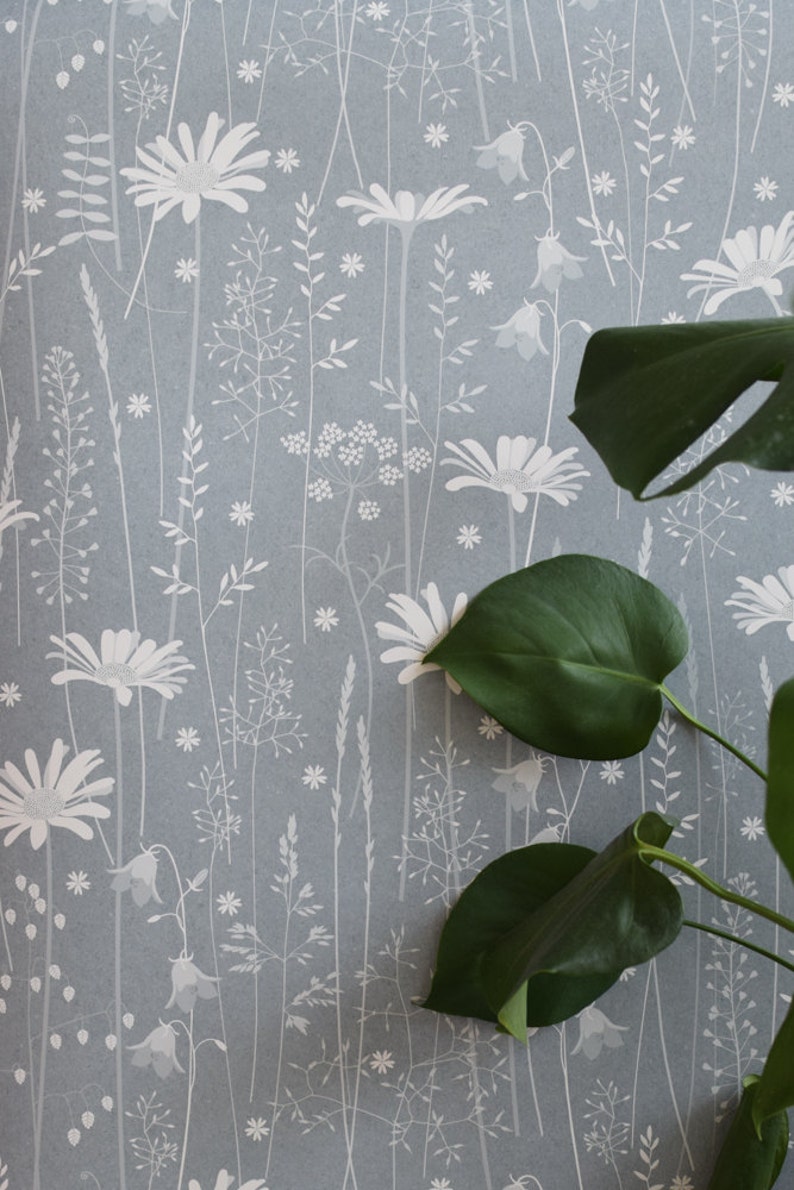 Daisy Meadow wallpaper in 'moonrise' by Hannah Nunn, a dusky blue wall covering with a summer meadow print of daisies, harebells and grasses image 1