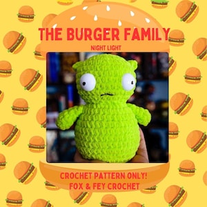 Könnte beinhalten: Grünes Häkel-Plüschtier mit großen Augen und einem kleinen Mund. Das Spielzeug ist in Form einer menschlichen Figur geformt und hält seine Arme ausgestreckt. Das Spielzeug sitzt auf einer Hand. Der Hintergrund ist ein gelbes Muster aus Comic-Hamburgern. Der Text "THE BURGER FAMILY NIGHT LIGHT CROCHET PATTERN ONLY! FOX & FEY CROCHET" befindet sich oben im Bild.