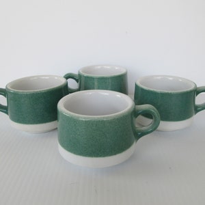 以下が含まれることがあります： 緑と白のセラミック製のコーヒーカップ4個セット。カップは白の縁と底に、中央に緑の帯があります。