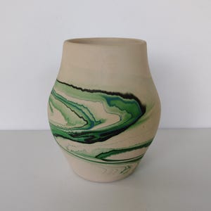 May include: A white ceramic vase with a green, blue, and black marbled design.