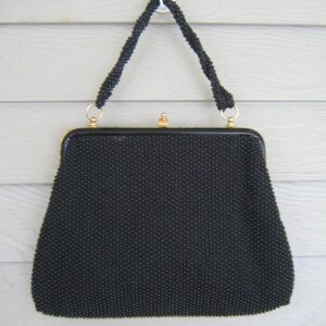 May include: A black beaded evening bag with a gold clasp and a black chain strap.