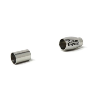 Puede incluir: Dos cierres de metal plateado para un brazalete. Un cierre es liso y el otro tiene las palabras "Custom Engraved" grabadas.