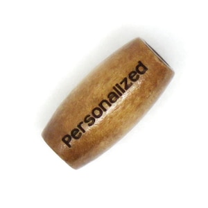 May include: A brown wooden bead with the word "Personalized" engraved on it.
