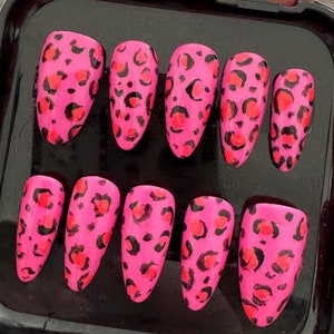 Op de afbeelding: Een set van tien nepnagels met een luipaardprint in roze en zwart in een zwarte plastic doos.