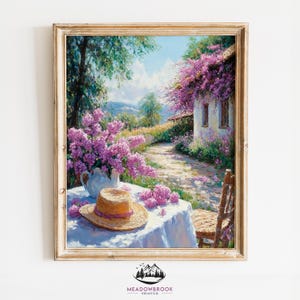 May include: A painting depicting a cottage with a white picket fence and a flourishing garden. The cottage is surrounded by purple flowers and a white picket fence. A straw hat and a teapot are on a table in the foreground.