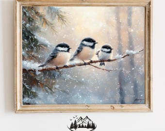 May include: A framed painting depicting three black-capped chickadees perched on a snow-covered branch in a winter woodland. The birds are facing right, with the nearest bird looking directly at the viewer. The background is a soft, muted blue and white, with a hint of yellow in the sky. The painting is framed in a light wood frame.
